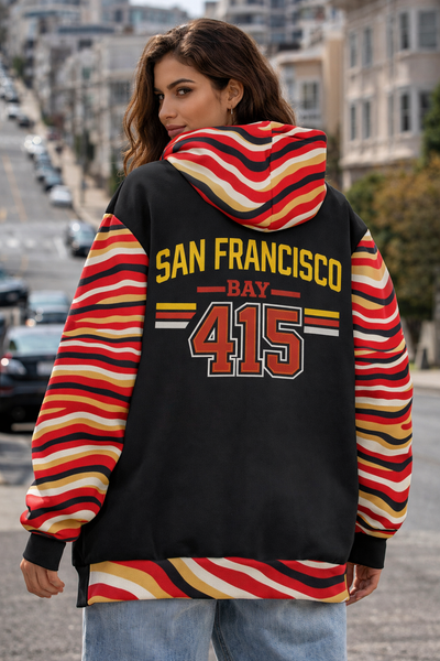 Person wearing a colorful hoodie with 'San Francisco Bay 415' text on a city street.