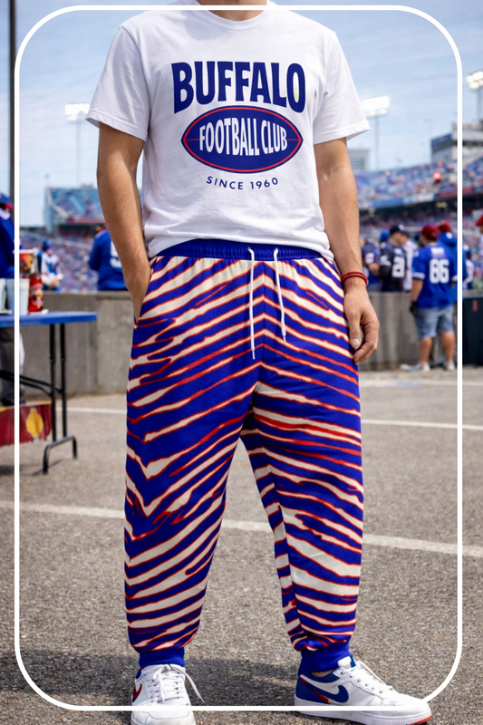 Person wearing a 'Buffalo Football Club' t-shirt and colorful striped pants at a sports event.