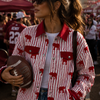 Woman in a red and white jacket with animal patterns at a sports event
