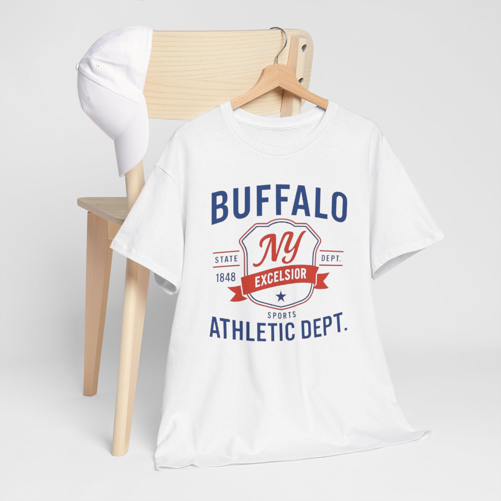 White t-shirt with 'Buffalo NY Excelsior Sports Athletic Dept.' text on a wooden chair.
