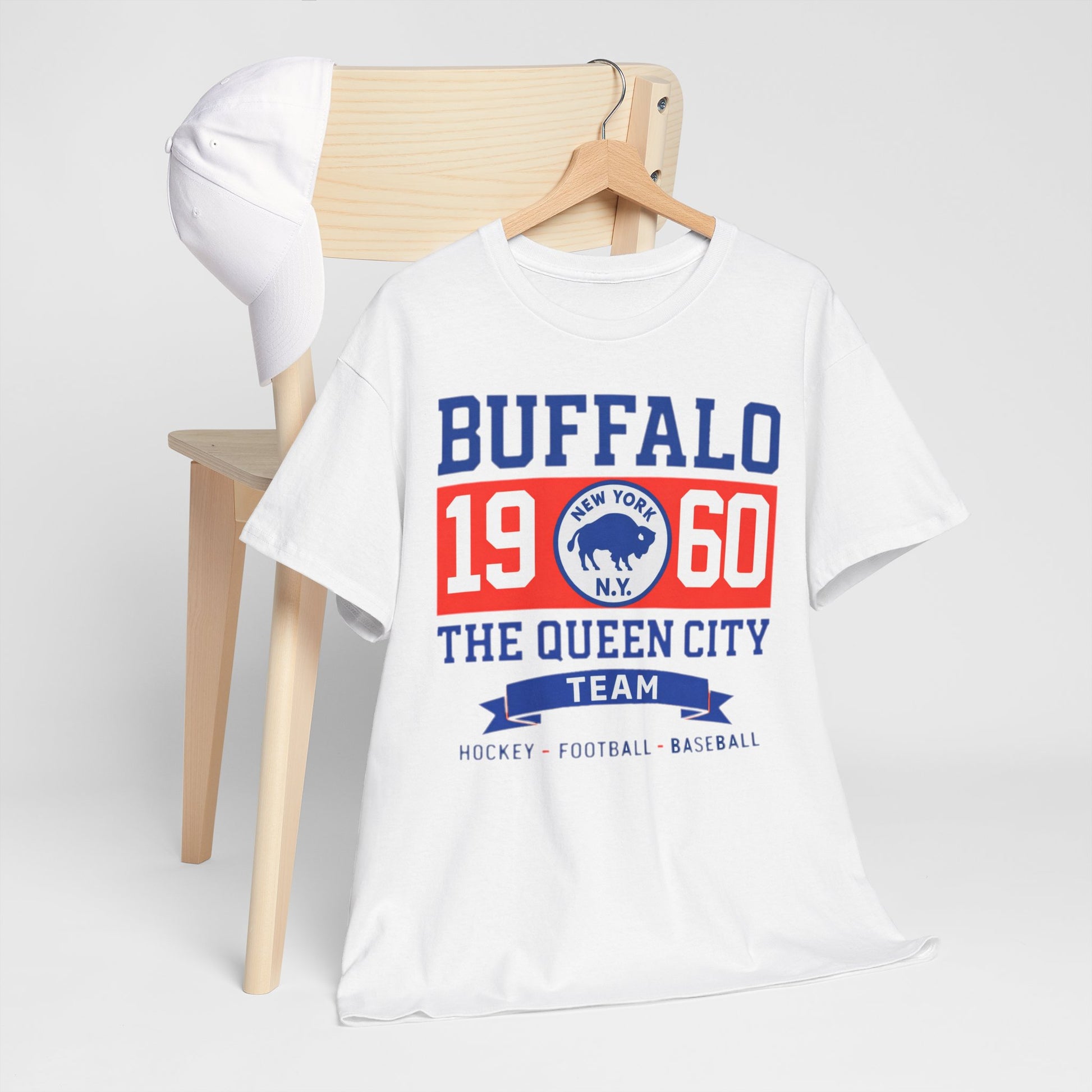 White t-shirt with 'Buffalo 1960 The Queen City Team' text on a wooden chair against a white background