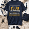 Navy t-shirt with '1988 Los Angeles' text, sneakers, cap, and accessories on a light background