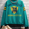 Teal sweatshirt with 'San Francisco' text, sneakers, coffee cup, and sunglasses on a textured surface.