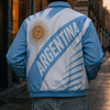Person wearing an Argentina jacket on a city street at sunset.