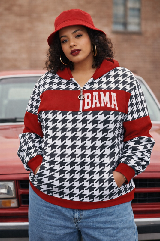 Person wearing a houndstooth patterned jacket with 'BAMA' text in front of a red car.