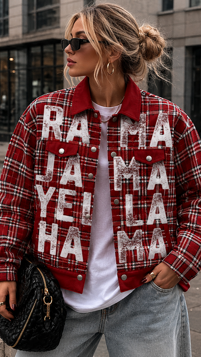 Person wearing a red plaid jacket with text, standing on a city street.
