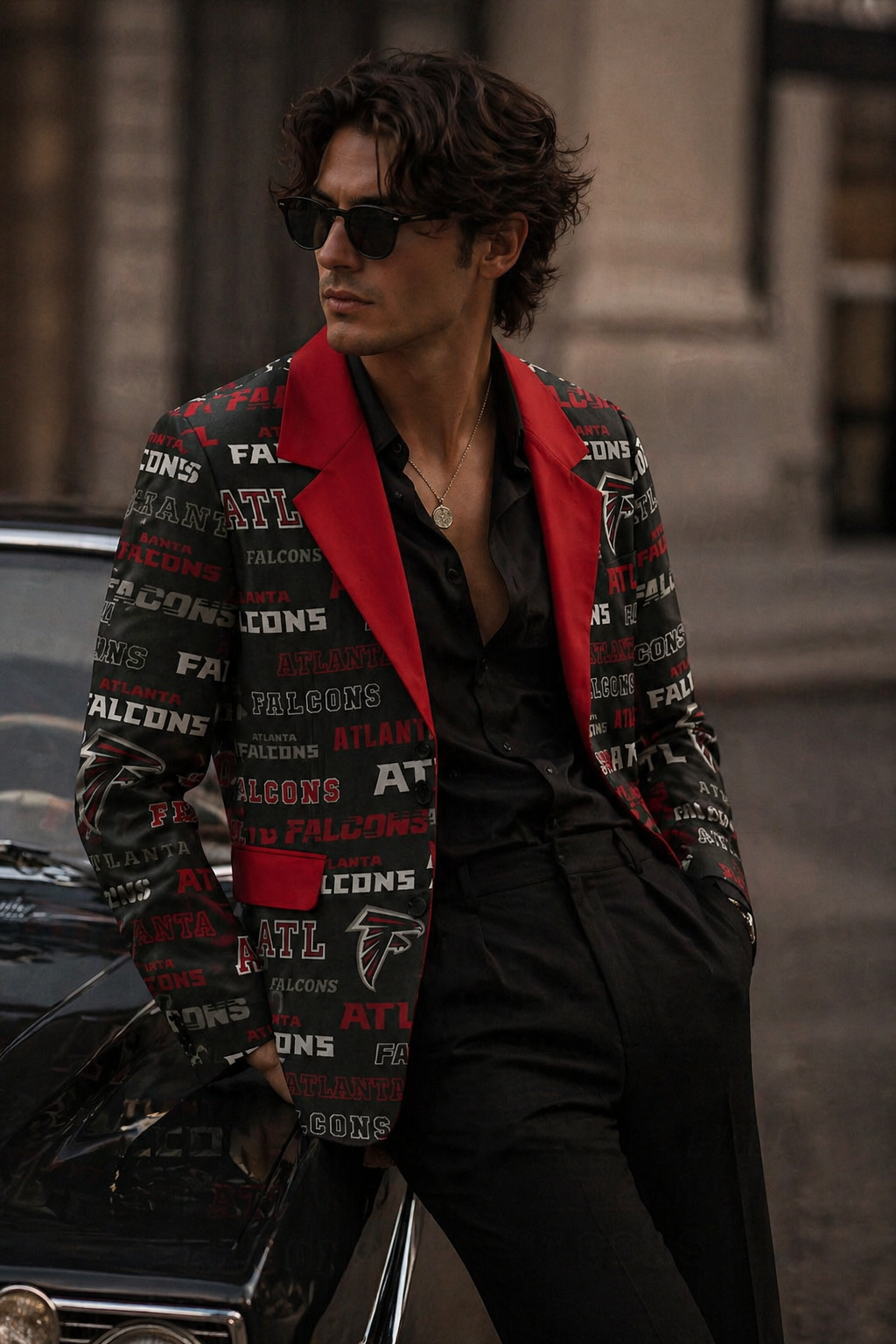 Man wearing a colorful jacket with logos and sunglasses, standing next to a car.