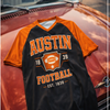 Black and orange 'Austin Football' t-shirt on a classic car