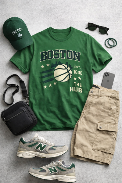 Green t-shirt with 'Boston' print, beige shorts, green sneakers, and accessories on a gray surface