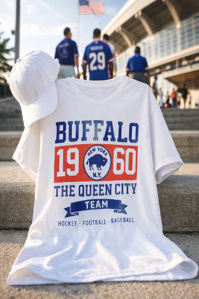 White t-shirt with 'Buffalo 1960 The Queen City Team' design on steps with people in the background