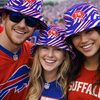Three people wearing Buffalo Bills-themed hats and clothing at a sports event.