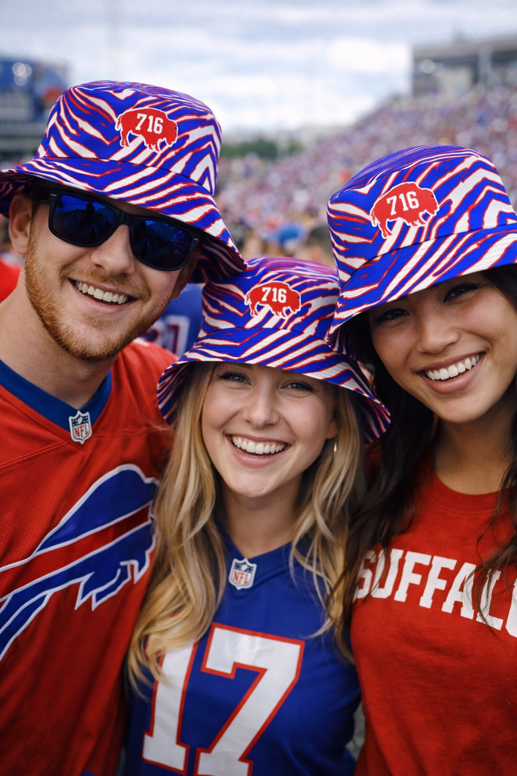 Three people wearing Buffalo Bills-themed hats and clothing at a sports event.