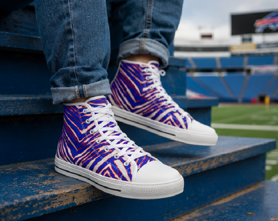 Person wearing blue and purple zebra print high-top sneakers with white soles on a stadium bench.