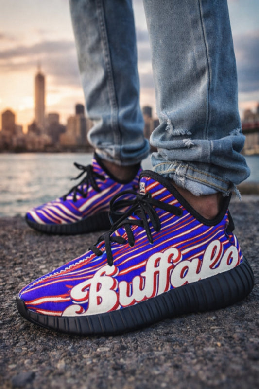 Colorful sneakers with 'Buffalo' branding worn by a person standing on a waterfront with a city skyline in the background.