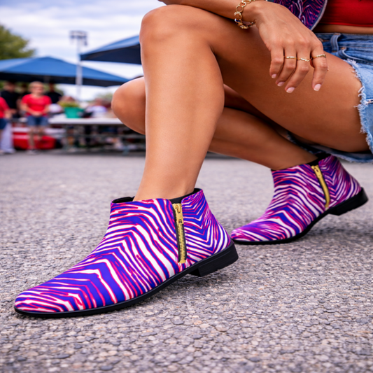Person wearing colorful zebra-patterned shoes on a street.
