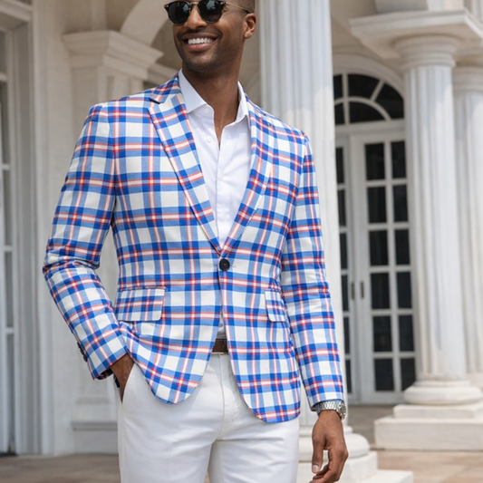 Man wearing a blue and red checkered blazer with white pants in front of a classical building.