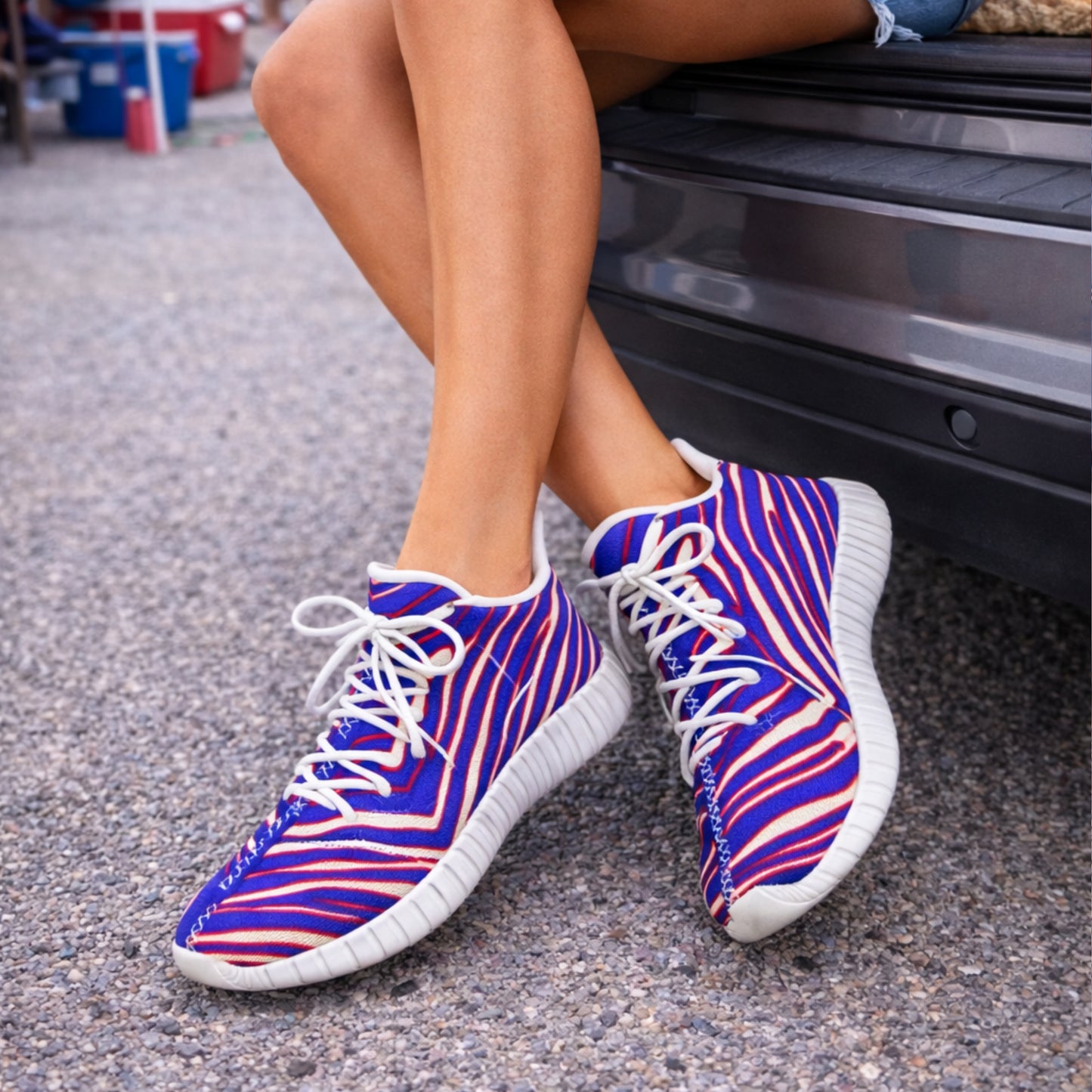 Buffalo bills sneakers. Person wearing blue and pink striped sneakers on a street.