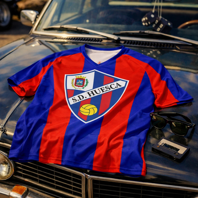 Blue and red sports jersey with a logo on a classic car