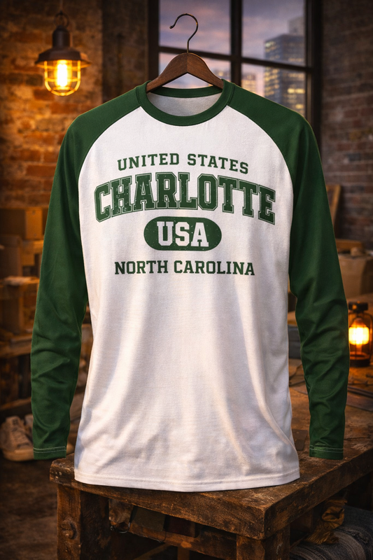 Green and white long-sleeve shirt with text on a wooden surface.