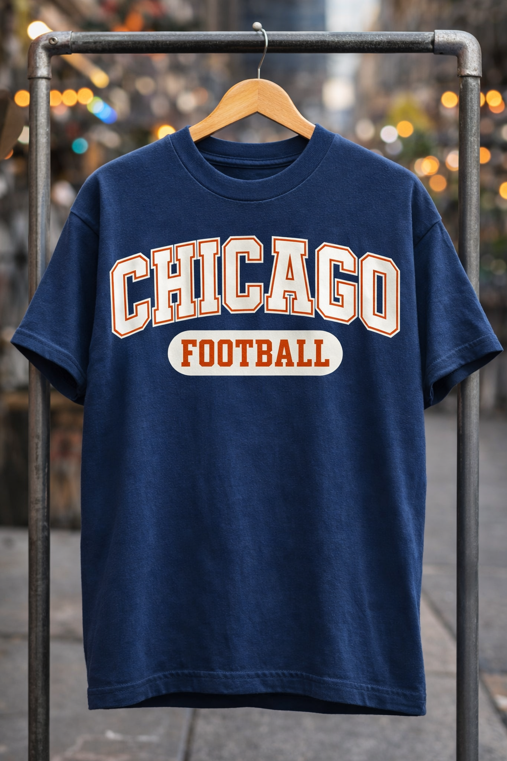 Navy blue t-shirt with 'Chicago Football' text on a hanger against a blurred background