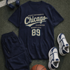 Navy athletic outfit with 'State University Chicago' t-shirt, shorts, sneakers, and basketball on a textured surface.