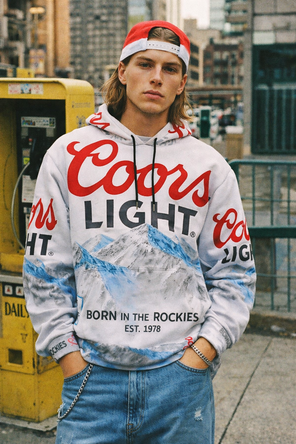 Person wearing a Coors Light hoodie with a cityscape background