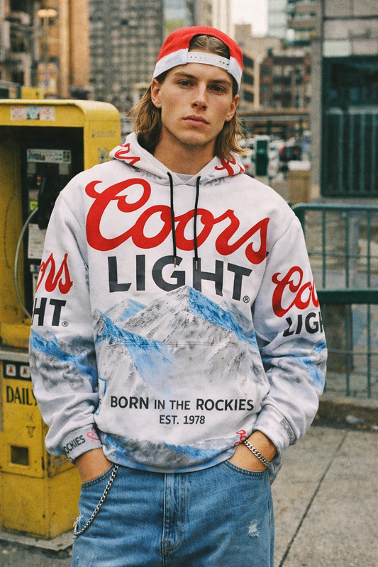 Person wearing a Coors Light hoodie with a cityscape background