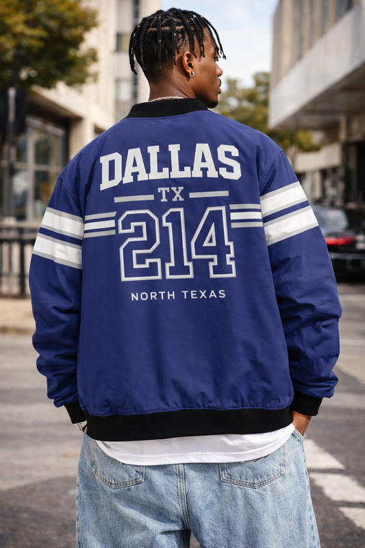 Person wearing a blue jacket with 'Dallas TX 214 North Texas' text on the back, standing on a street.