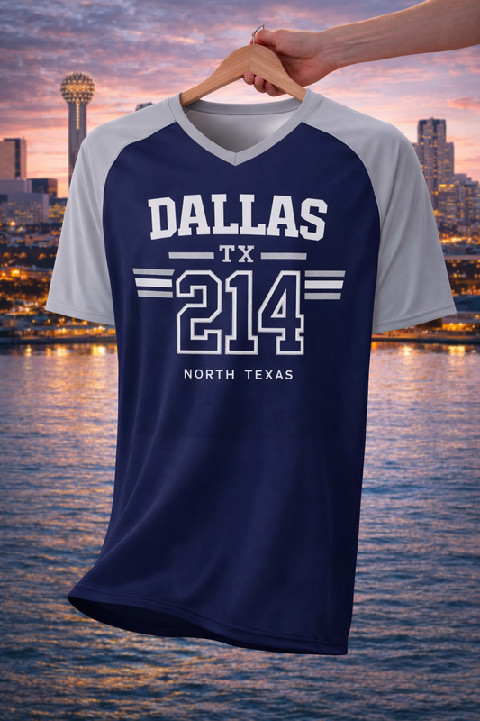 Navy and gray t-shirt with 'Dallas TX 214 North Texas' text on a hanger against a cityscape background.