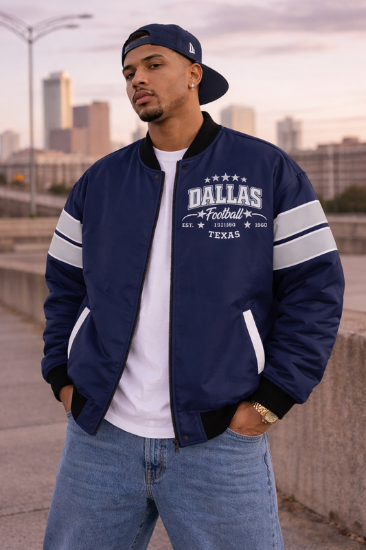 Man wearing a navy blue jacket with 'Dallas Football Texas' text, standing in an urban setting.