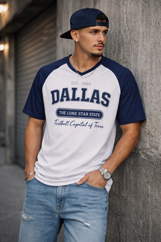 Man wearing a 'Dallas' t-shirt leaning against a wall.