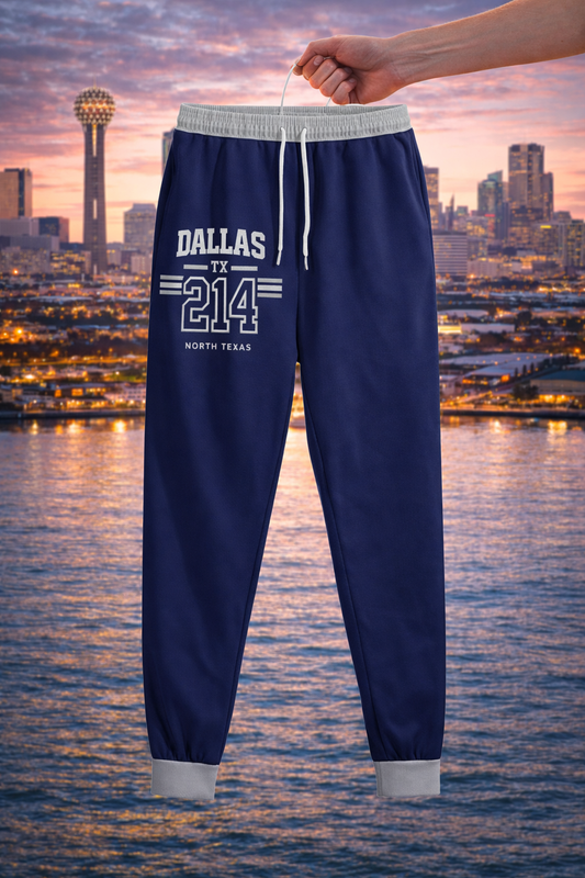 Navy blue jogger pants with 'Dallas TX 214' text held up against a city skyline at sunset.