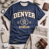 Blue 'Colorado Denver' t-shirt with accessories on a light gray surface