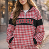 Woman wearing a red and black plaid jacket with 'Georgia' text, standing on a street.