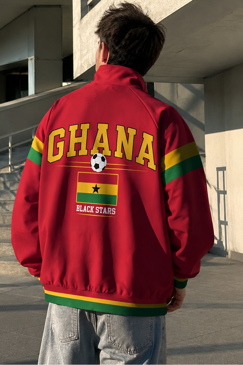 Person wearing a red jacket with 'Ghana Black Stars' text and flag design, standing in front of a building.
