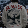 Person wearing a Glacier National Park sweatshirt overlooking a snowy mountain village at sunset.