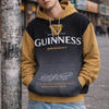 Person wearing a Guinness hoodie leaning against a street lamp.