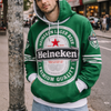 Person wearing a green Heineken hoodie on a city street