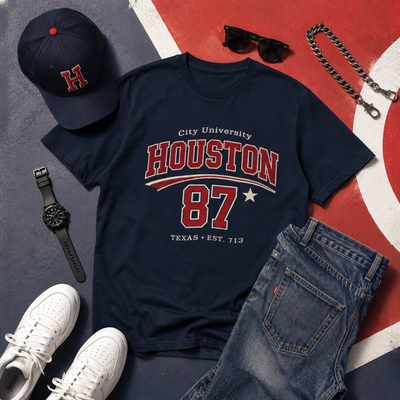 Navy t-shirt with 'Houston 87' design, cap, jeans, sneakers, and accessories on a colorful background