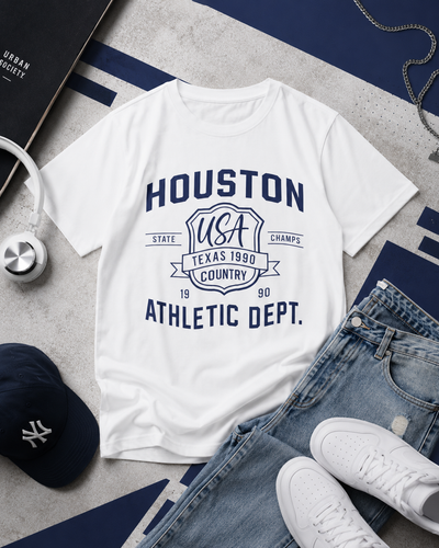White t-shirt with 'Houston Athletic Dept.' design on a gray surface with jeans, sneakers, and a cap.