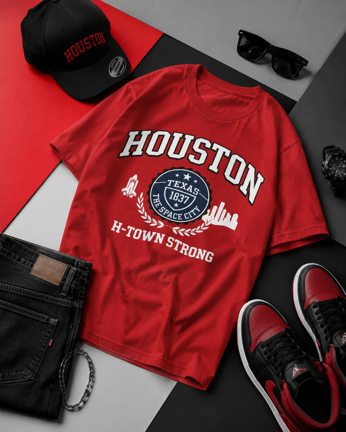 Red 'Houston' t-shirt with accessories on a gray surface