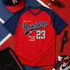 Red and navy sports-themed shirt with 'Houston' and number '23', surrounded by accessories on a red and blue background.