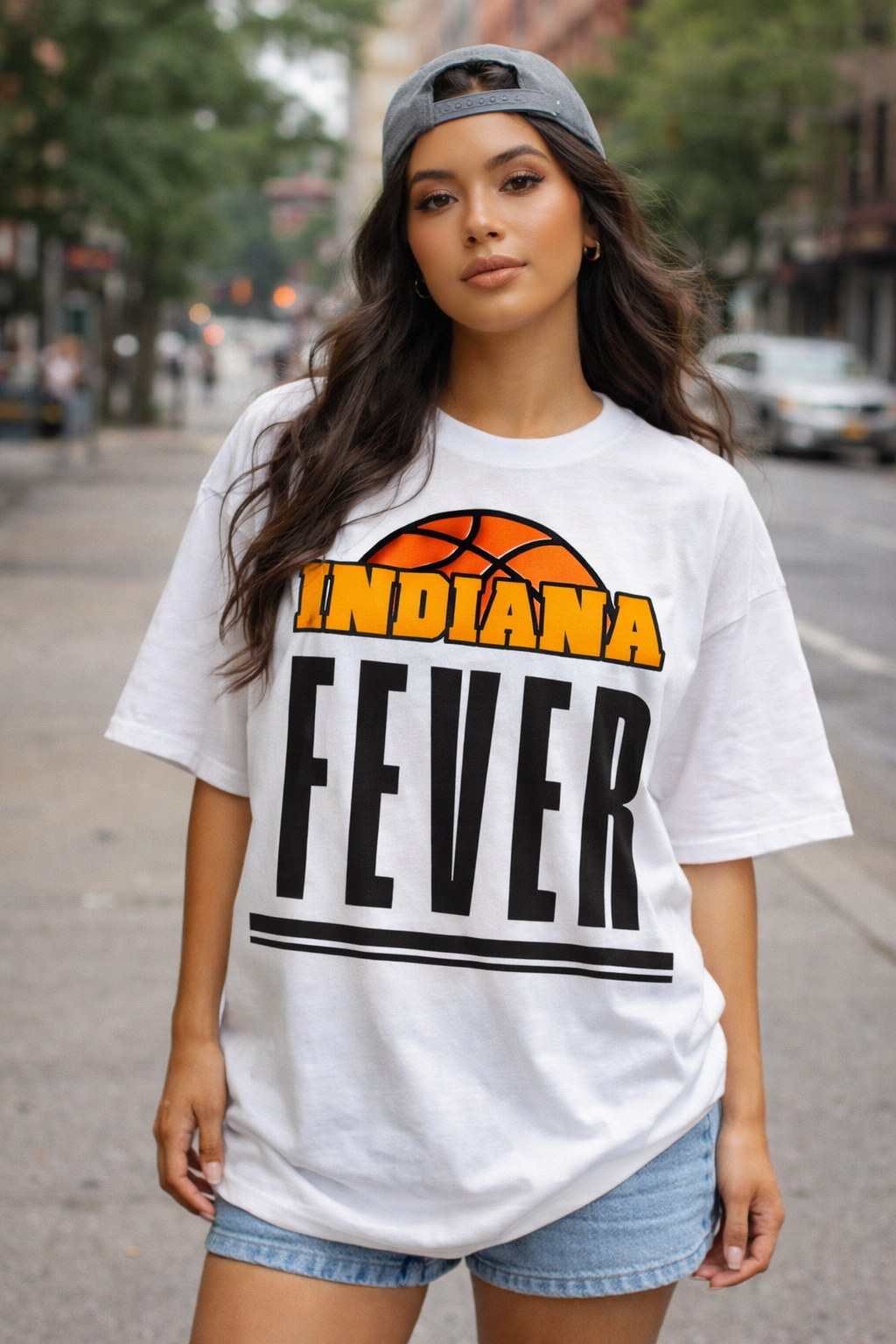 Woman wearing a white t-shirt with 'Indiana Fever' printed on it, standing on a street.