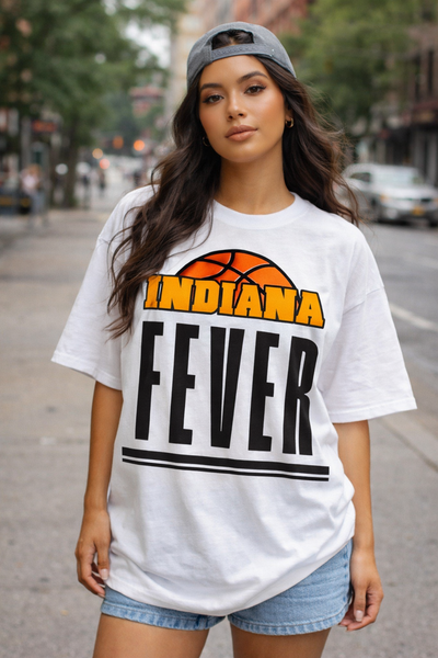 Woman wearing a white t-shirt with 'Indiana Fever' printed on it, standing on a street.