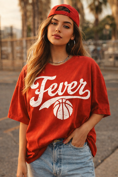 Woman wearing a red 'Fever' t-shirt with a basketball graphic outdoors.