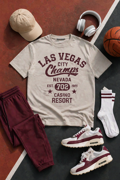 T-shirt with 'Las Vegas City Champs' design, maroon pants, white sneakers, cap, socks, and basketball on a dark surface.