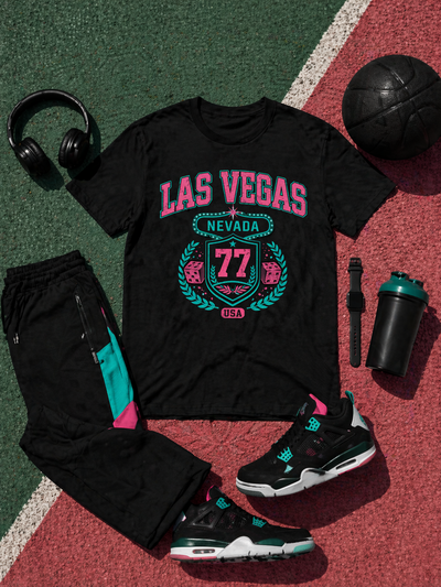 Black t-shirt with 'Las Vegas' design, sneakers, headphones, and a water bottle on a sports court.