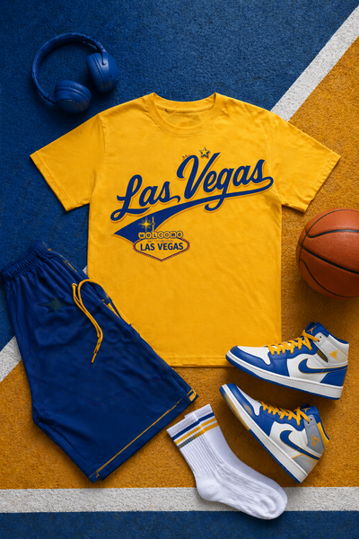 Yellow t-shirt with 'Las Vegas' design, blue shorts, white socks, blue sneakers, and basketball on a blue and orange sports court.
