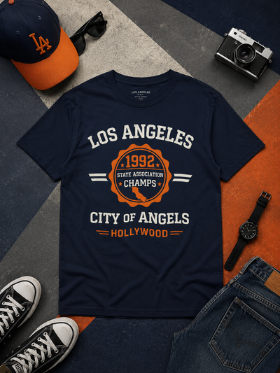 Navy blue t-shirt with 'Los Angeles' text and graphics on a patterned surface with accessories.