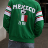 Person wearing a green Mexico-themed jacket with soccer design outdoors.